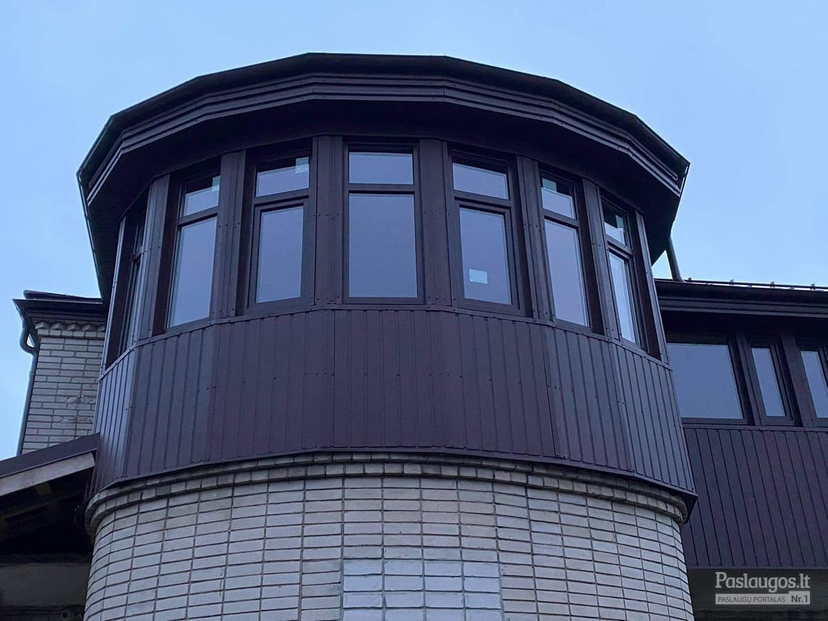 Apvalaus bokšto skardinimas – sodrus tamsiai rudas metalas naktiniame apšvietime