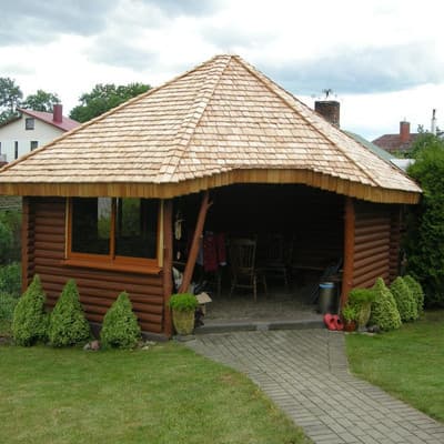 Šešiakampė rąstinė altana su kedro čerpių stogu – pilnas vaizdas iš priekio