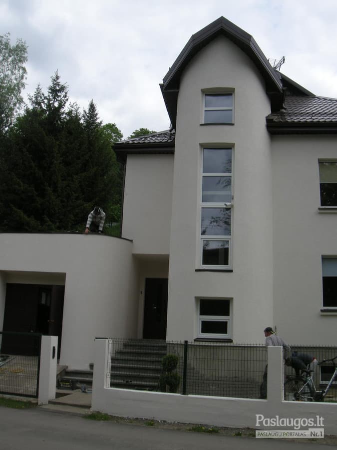 Namas su puošnios formos pilkų čerpių stogu – vaizdas iš gatvės