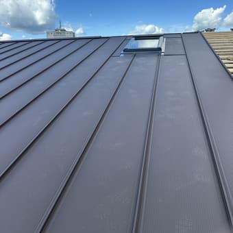 Skardinis stogas su stogo langu – antracito spalvos danga, mėlynas dangus