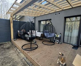 Medinė terasa su pergola ir polikarbonatu – baldai ir šuo priekyje