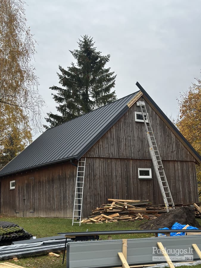 Medinis ūkio pastatas stogo keitimo procese – nauja tamsios skardos danga montuojama
